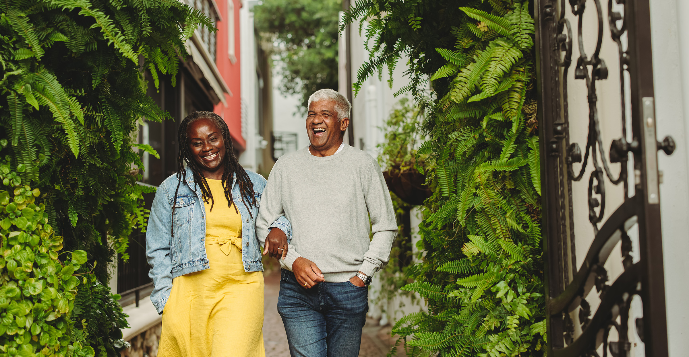 Happy senior couple laughing cheerfully while walking together outdoors. Cheerful senior couple spending some quality time together after retirement.